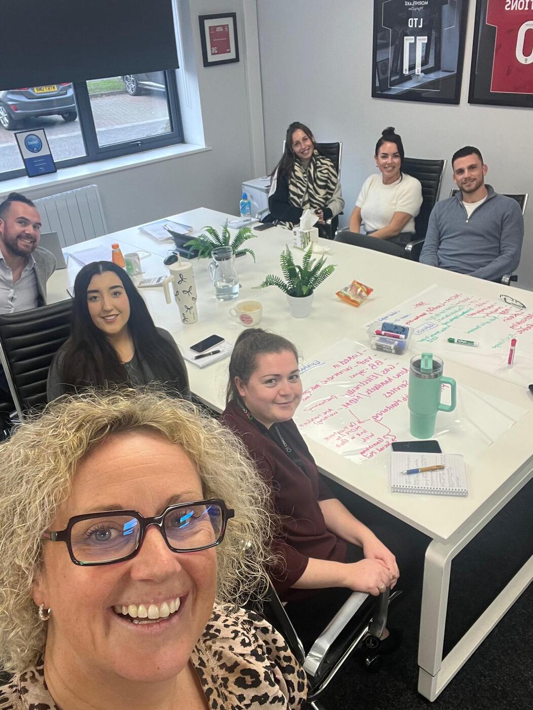 Anna with the CAN Solutions team around a training table.